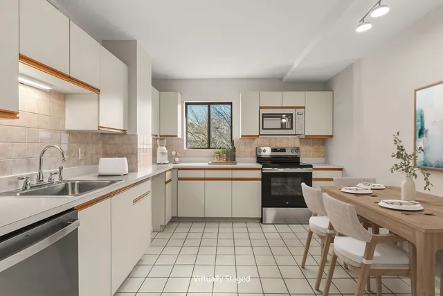 a kitchen with a sink white cabinets and appliances