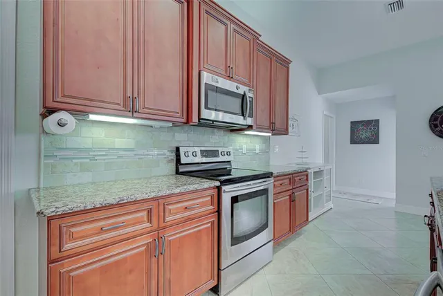 a kitchen with stainless steel appliances granite countertop a stove a sink and a wooden cabinets