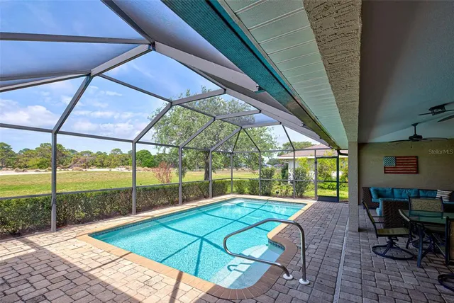 a living room with furniture kitchen view and a large window