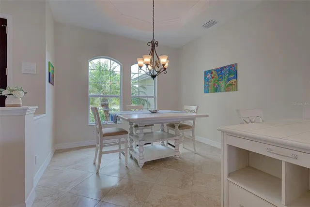 a view of a dining room with furniture a chandelier and window