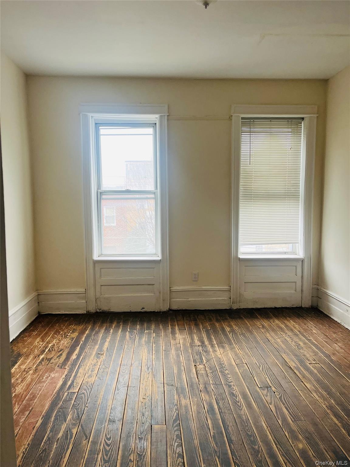 62-18 60th Drive Queens, NY 11378 - Photo 11 of 14 Unfurnished room with dark wood-type flooring