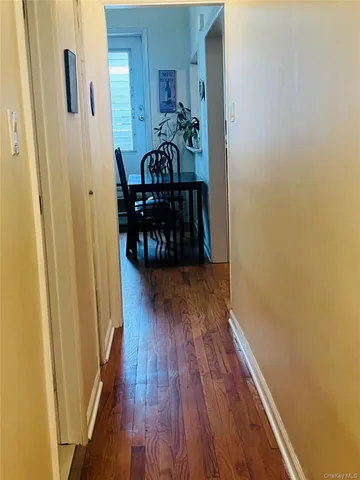 a view of a hallway with wooden floor and stairs