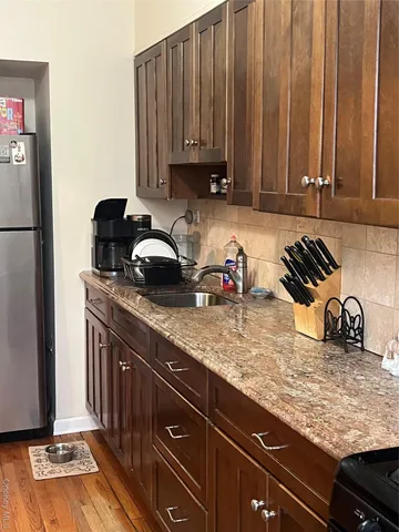 a kitchen with granite countertop a sink a stove and cabinets