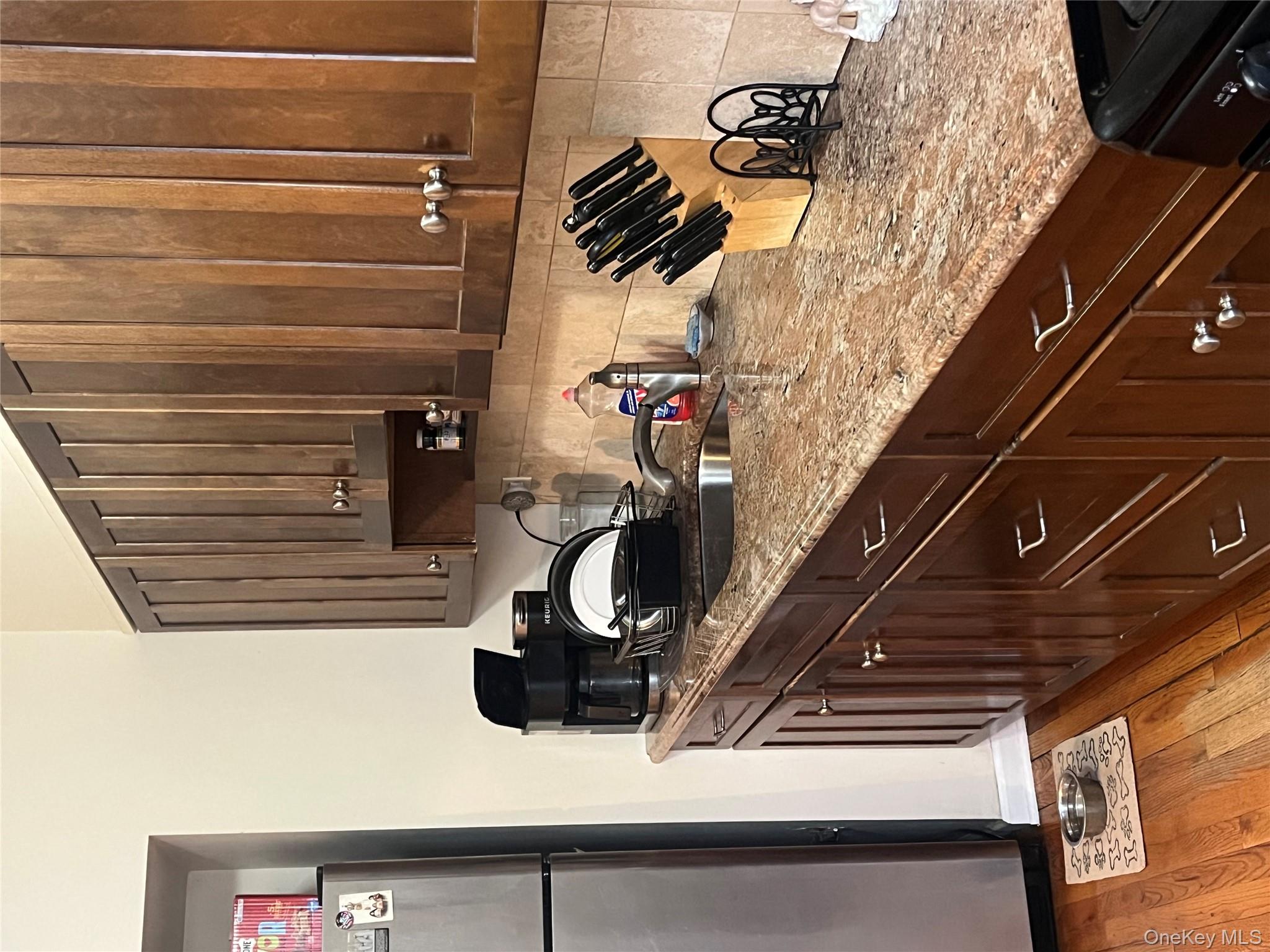 62-18 60th Drive Queens, NY 11378 - Photo 6 of 14 Kitchen with refrigerator, tasteful backsplash, sink, light stone counters, and light wood-type flooring