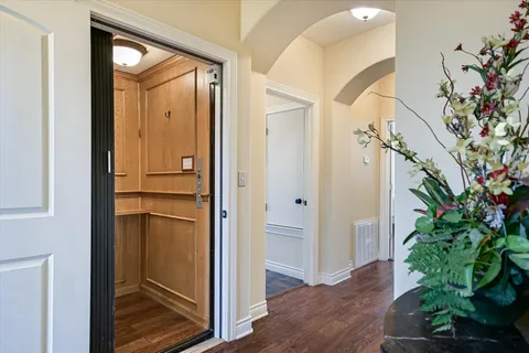 a view of a hallway with wooden floor and front door