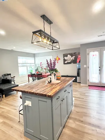 a kitchen with kitchen island granite countertop a sink cabinets and wooden floor