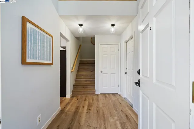 a view of a hallway with wooden floor and staircase