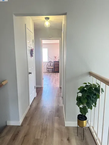 a view of a hallway with wooden floor and a glass door