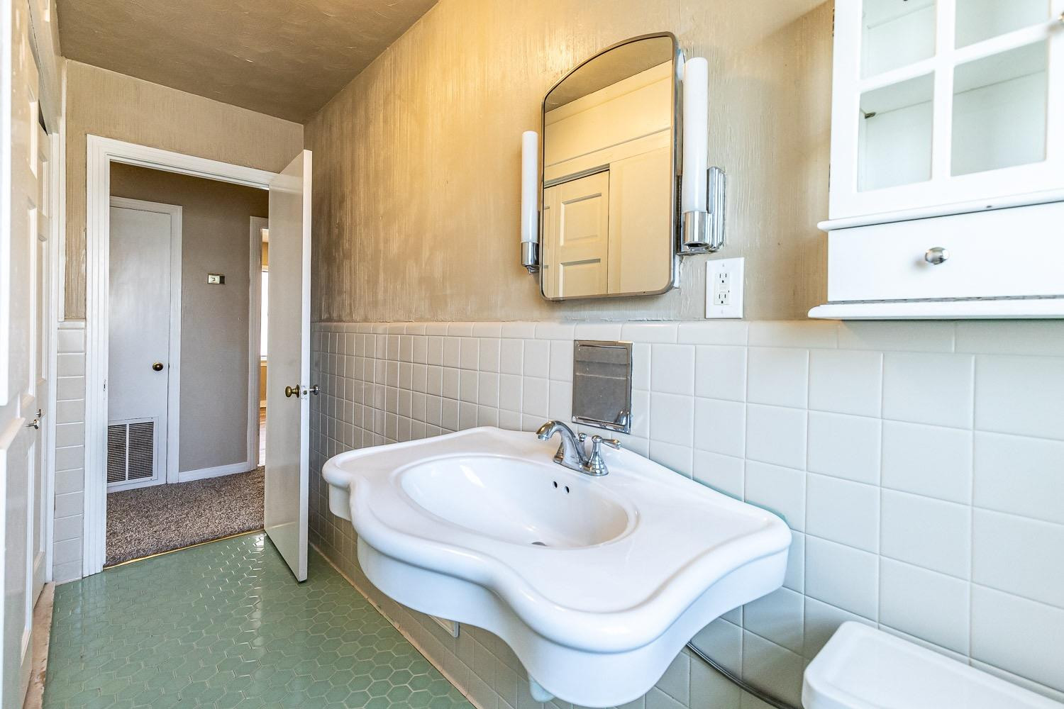 3708 27th Street Lubbock, TX 79410 - Photo 19 of 23 a bathroom with a toilet sink and mirror