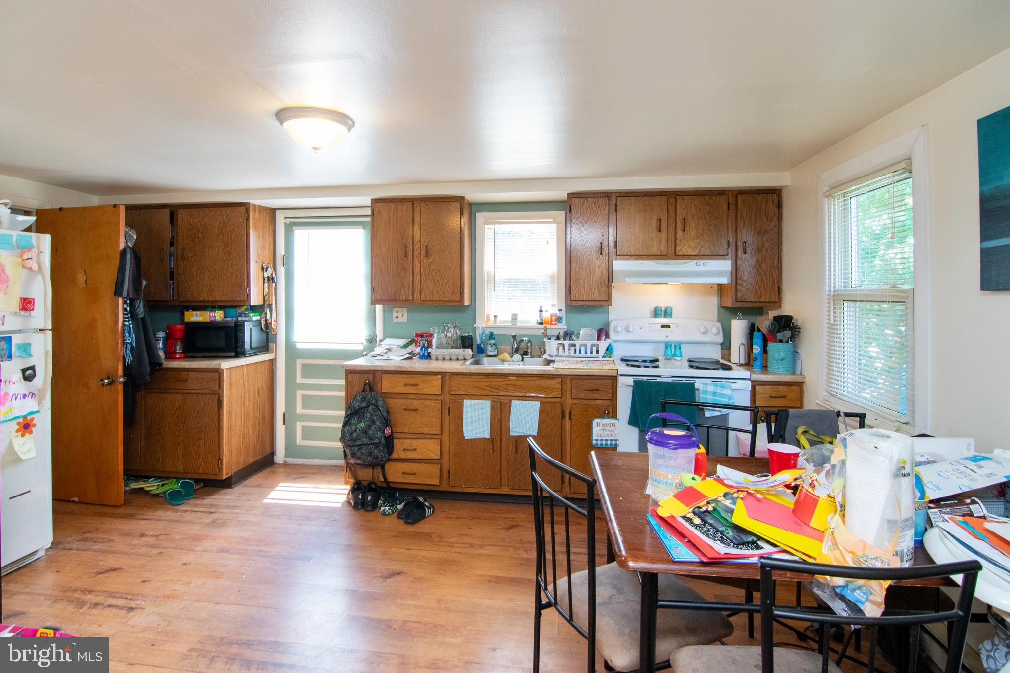 8438 Church Road Pasadena, MD 21122 - Photo 23 of 25 a room with kitchen island dining table wooden floor and a window