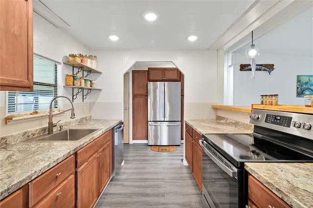 a kitchen with stainless steel appliances granite countertop a sink and a stove