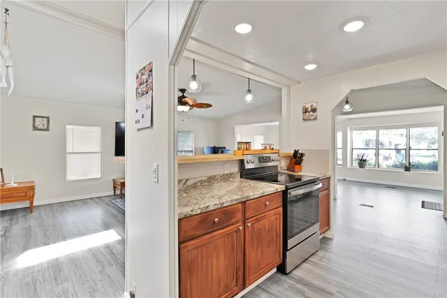 a kitchen with granite countertop a sink stove and cabinets