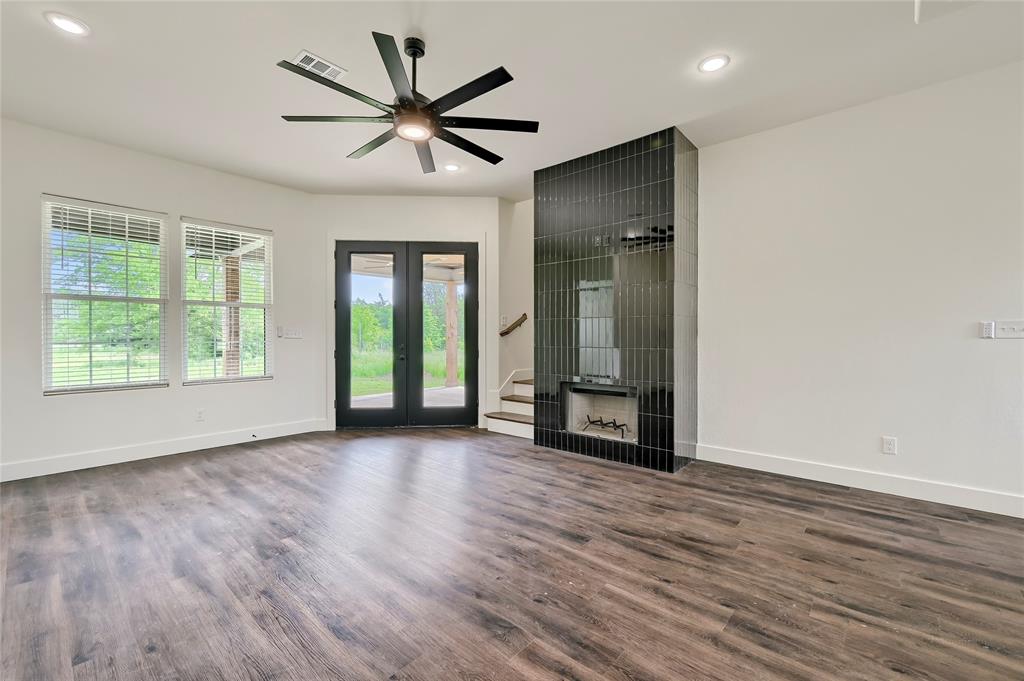 6091 Fm-1753 Denison, TX 75021 - Photo 9 of 40 an empty room with wooden floor a ceiling fan and windows