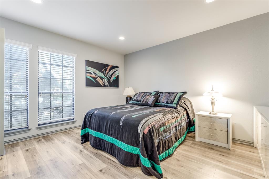 15221 Berry Trail, Unit 405 Dallas, TX 75248 - Photo 11 of 15 a bedroom with a bed a mirror and a large window