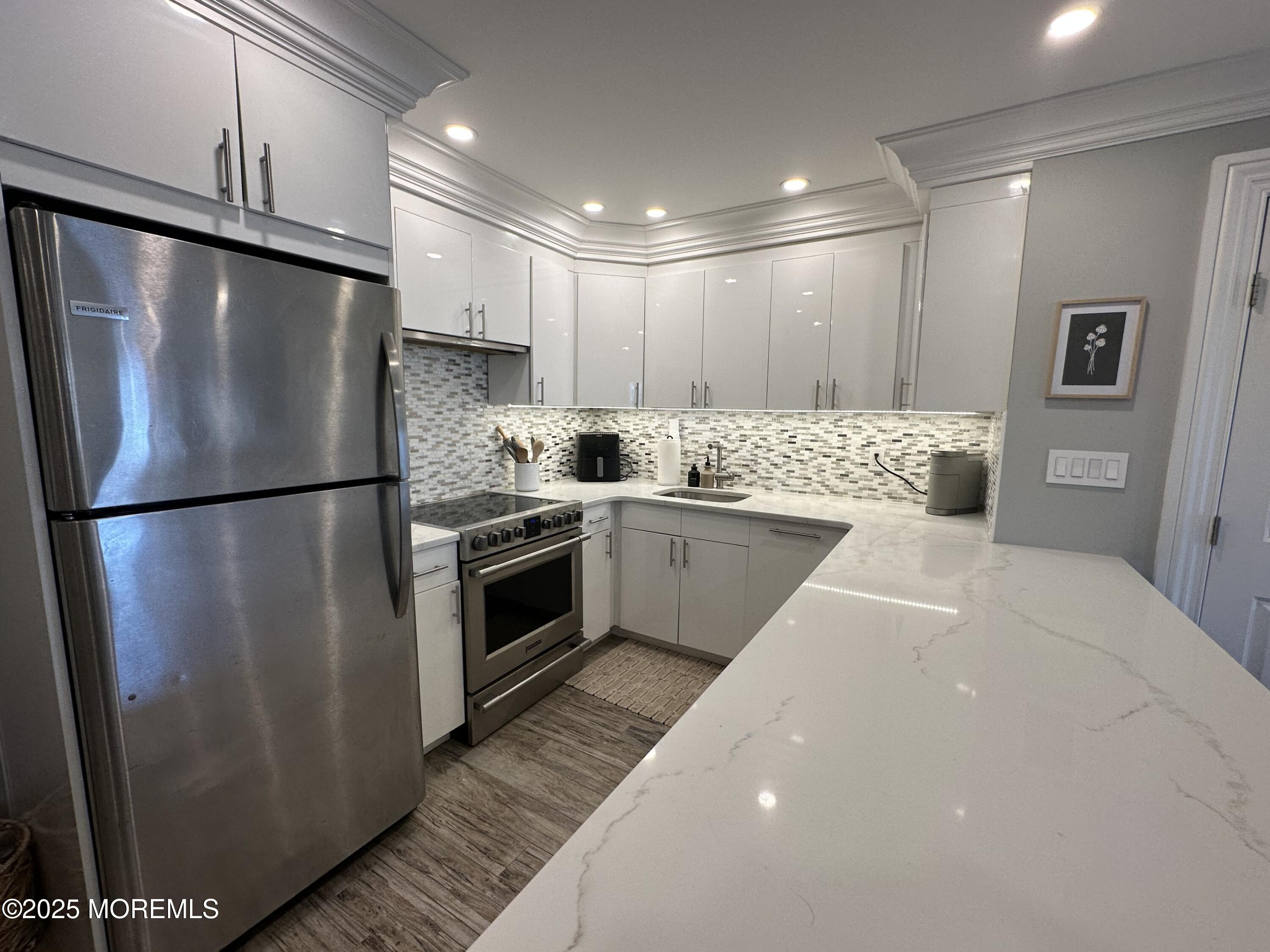 1501 Ocean Avenue, Unit A15 Belmar, NJ 07719 - Photo 7 of 17 a kitchen with stainless steel appliances a refrigerator sink and cabinets