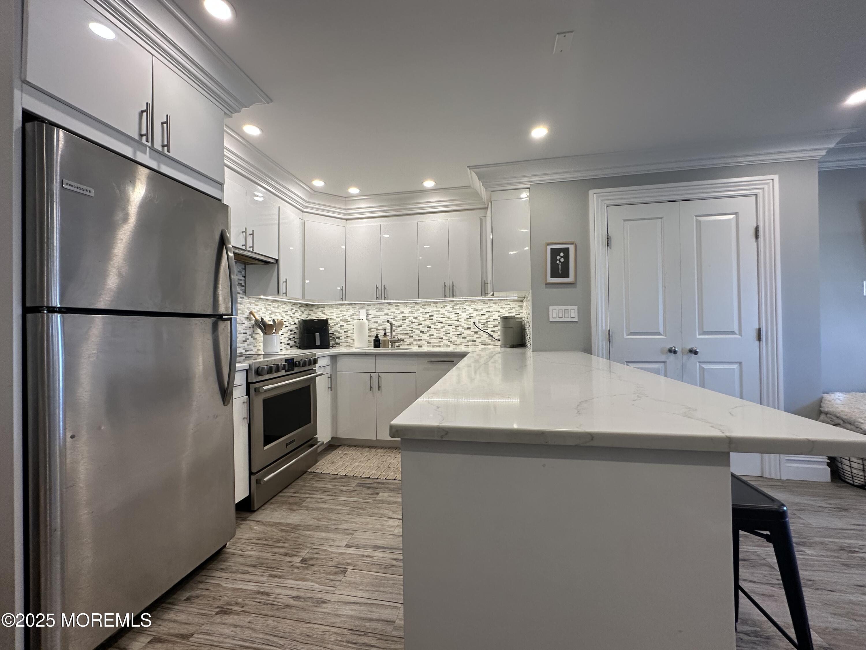 1501 Ocean Avenue, Unit A15 Belmar, NJ 07719 - Photo 8 of 17 a kitchen with kitchen island a sink stainless steel appliances and refrigerator