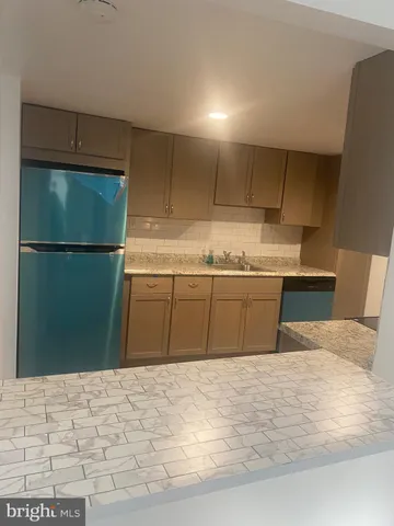a kitchen with a sink a refrigerator and a stove top oven