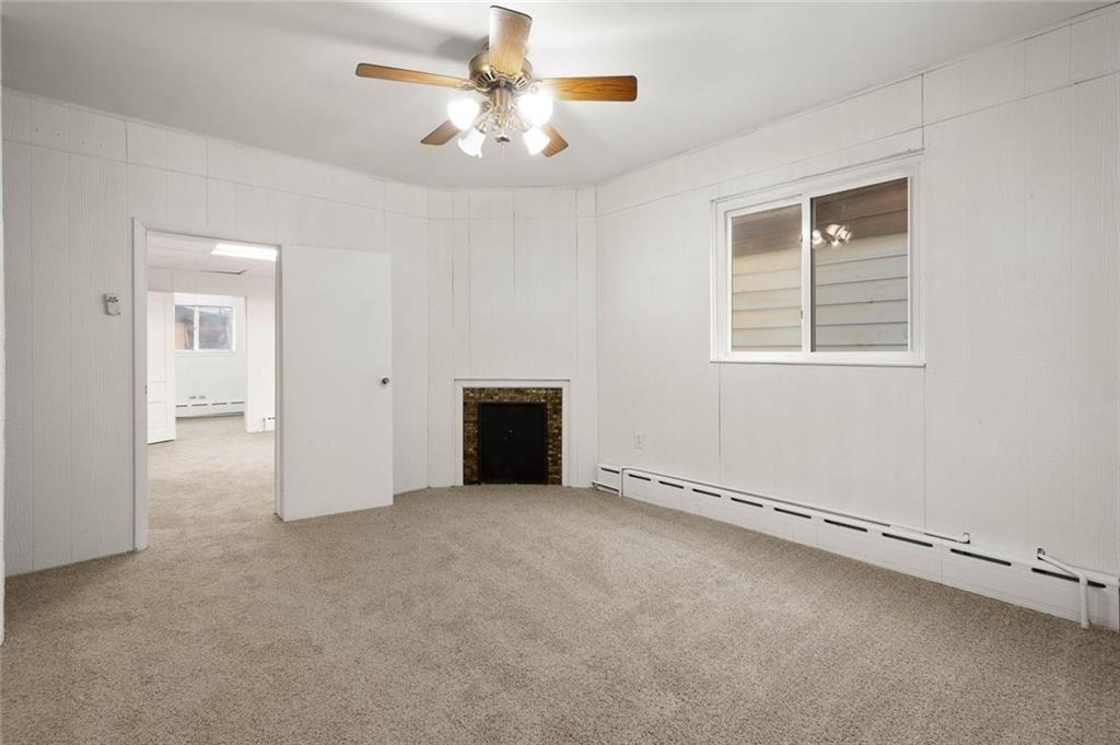 916 2nd Street McKees Rocks, PA 15136 - Photo 4 of 26 an empty room with chandelier fan and windows