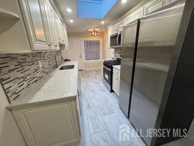 a kitchen with granite countertop a stove and a microwave