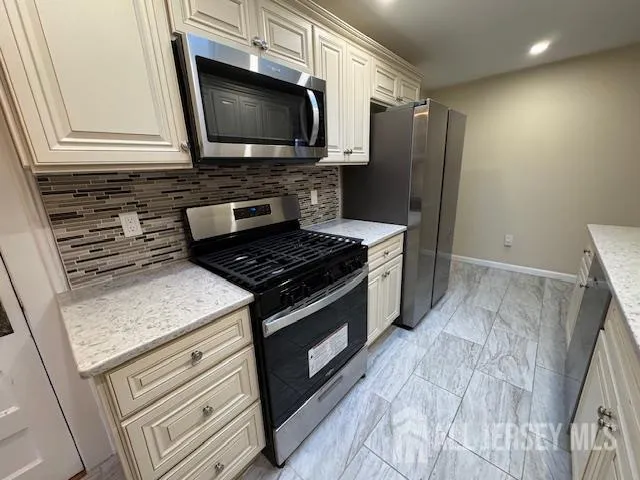 a kitchen with granite countertop a sink stove and cabinets