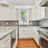 a kitchen with granite countertop a sink stainless steel appliances and cabinets