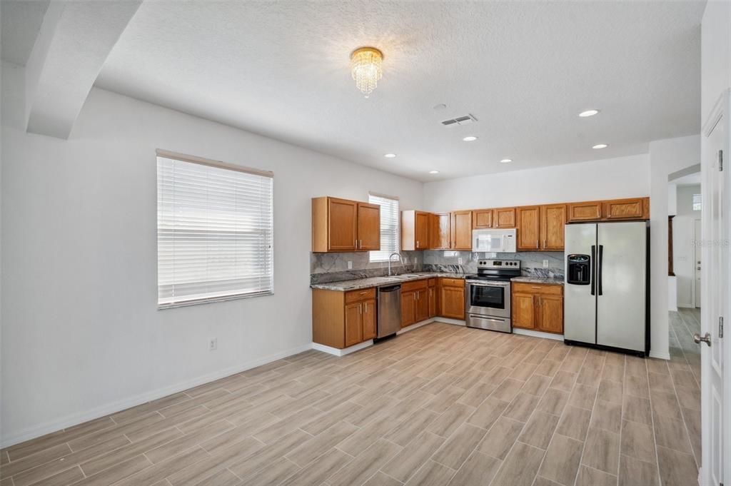 12351 Ridgedale Drive Hudson, FL 34669 - Photo 11 of 54 a kitchen with stainless steel appliances granite countertop a stove a sink a refrigerator white cabinets and wooden floor