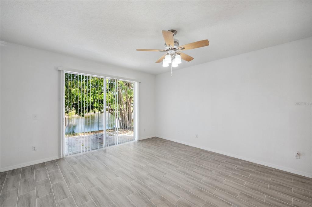 12351 Ridgedale Drive Hudson, FL 34669 - Photo 14 of 54 an empty room with wooden floor fan and windows