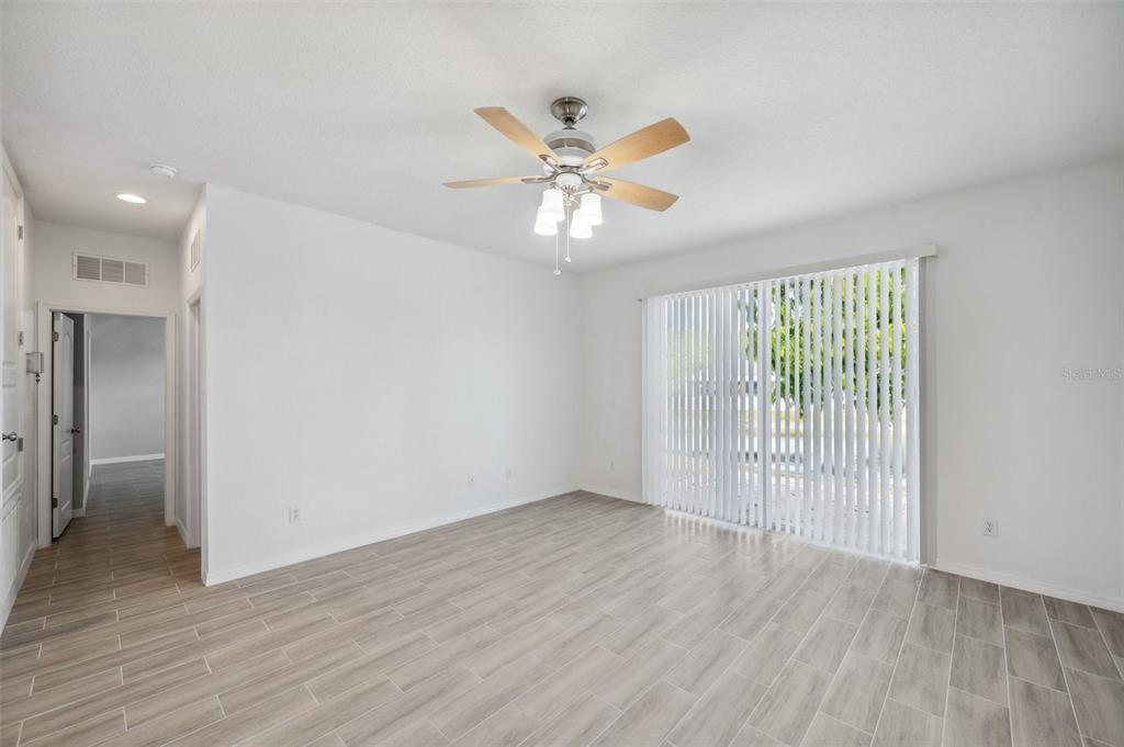 12351 Ridgedale Drive Hudson, FL 34669 - Photo 15 of 54 an empty room with wooden floor fan and windows