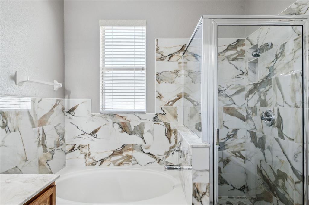 12351 Ridgedale Drive Hudson, FL 34669 - Photo 25 of 54 a bath tub sitting next to a white sink and a mirror