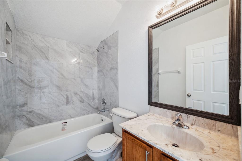 12351 Ridgedale Drive Hudson, FL 34669 - Photo 41 of 54 a bathroom with a granite countertop sink toilet and shower