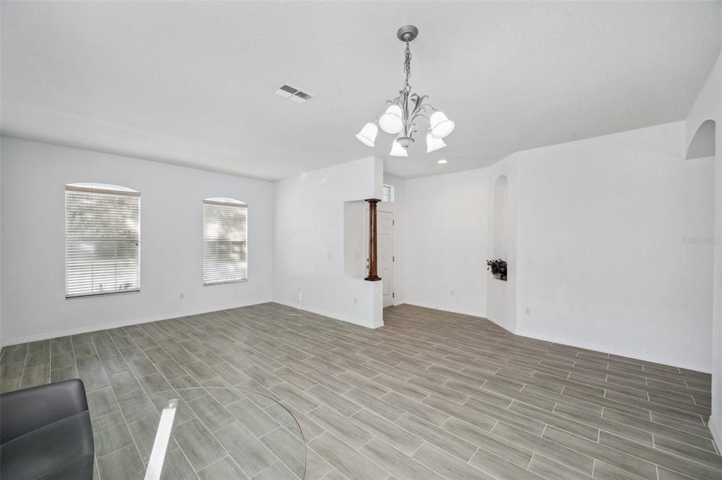 12351 Ridgedale Drive Hudson, FL 34669 - Photo 6 of 54 a view of empty room with wooden floor and window