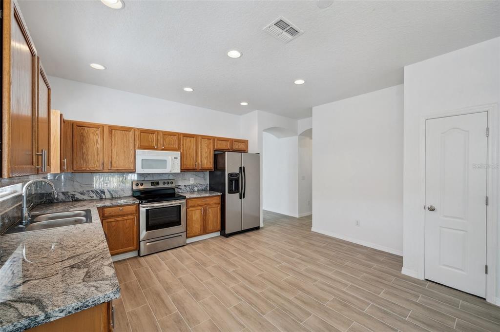 12351 Ridgedale Drive Hudson, FL 34669 - Photo 9 of 54 a large kitchen with stainless steel appliances granite countertop a stove a sink and a refrigerator