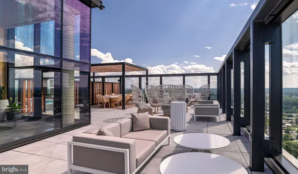a living room with patio furniture and a potted plant