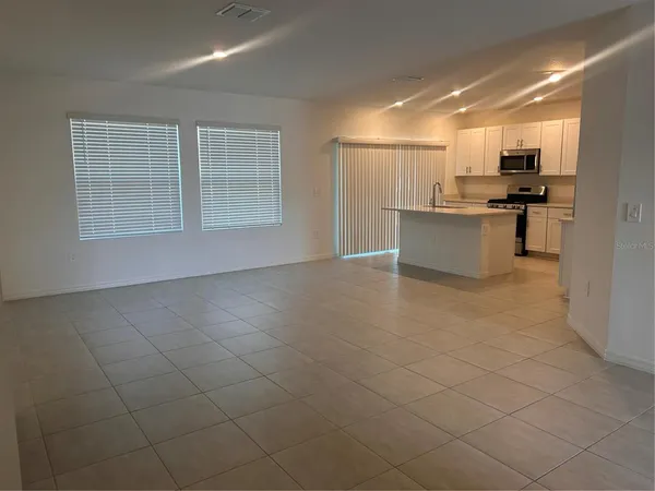 a view of kitchen with stainless steel appliances kitchen island granite countertop a sink and cabinets