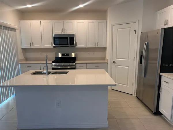 a kitchen with stainless steel appliances a refrigerator a stove a microwave and sink