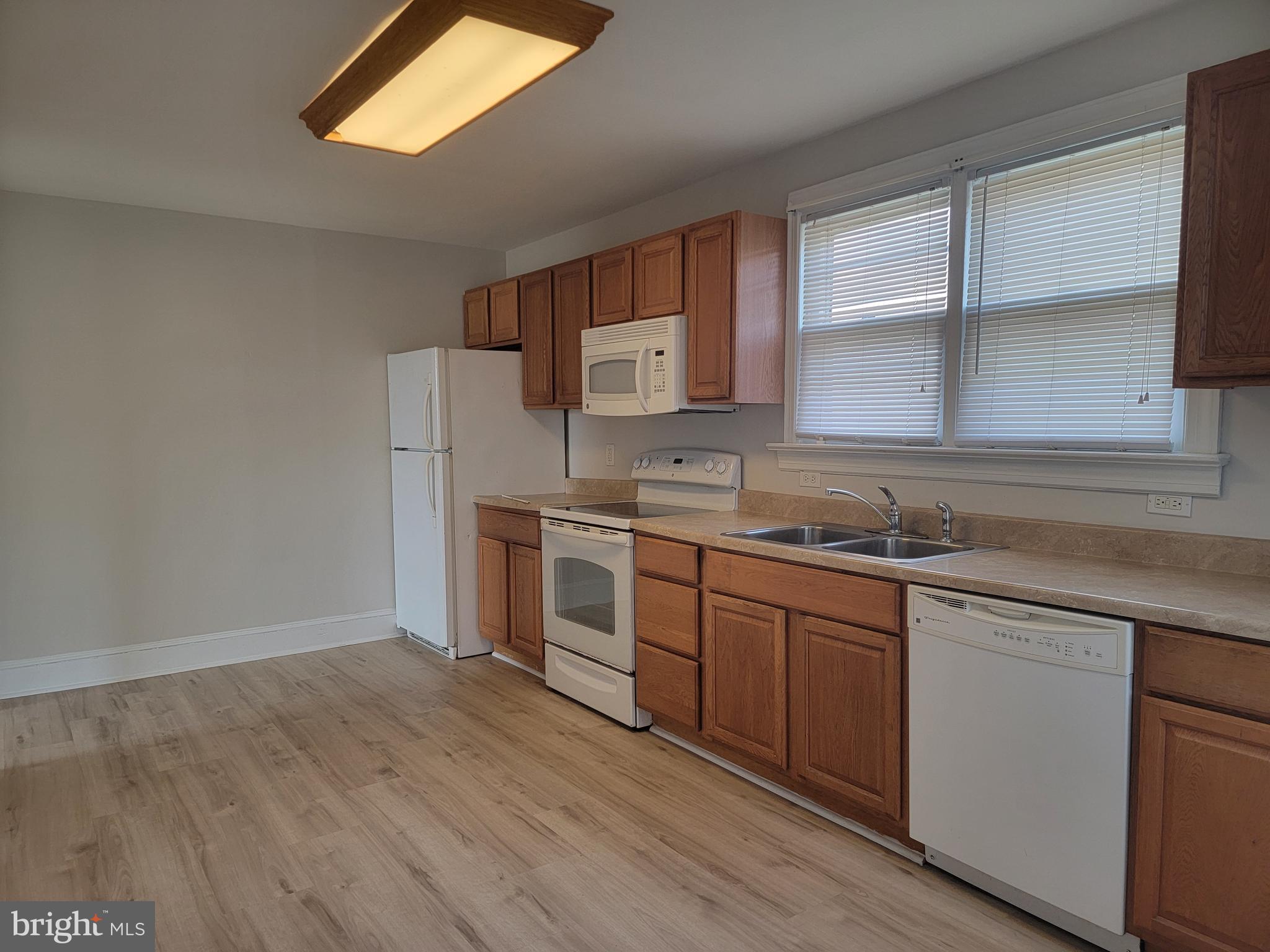 1111 Bayview Road Middletown, DE 19709 - Photo 2 of 15 a kitchen with stainless steel appliances granite countertop a sink a stove a refrigerator with grey cabinets and wooden floor