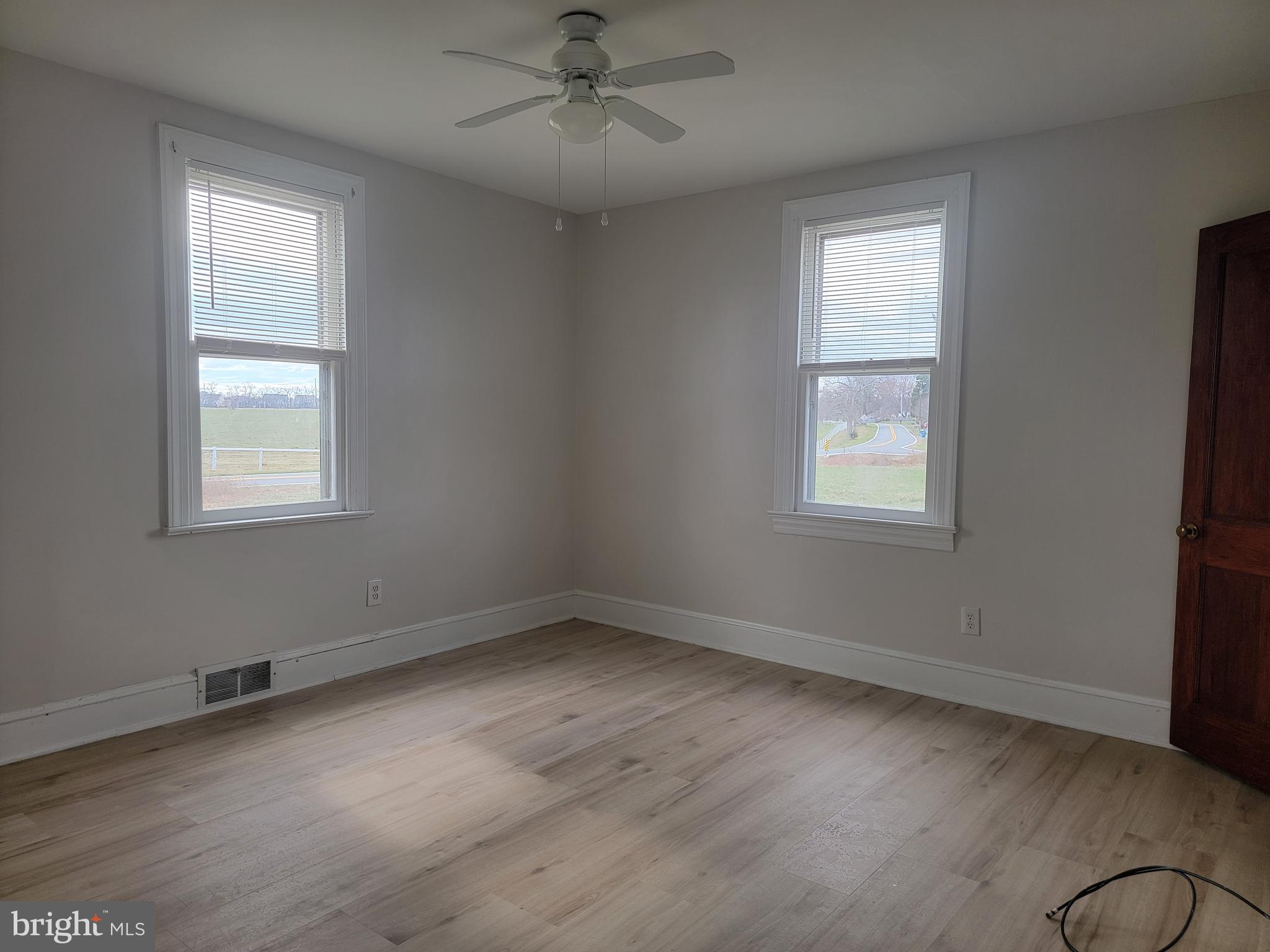 1111 Bayview Road Middletown, DE 19709 - Photo 5 of 15 a view of an empty room with a window and wooden floor