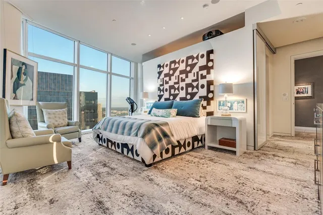 a bedroom with a bed a couch and large window