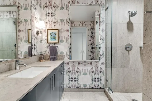 a bathroom with a granite countertop shower sink and mirror