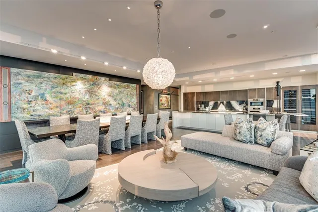 a living room with furniture a chandelier and a large window