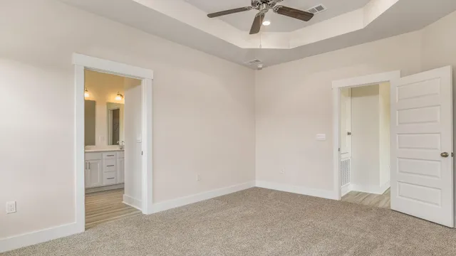 an empty room with windows and fan