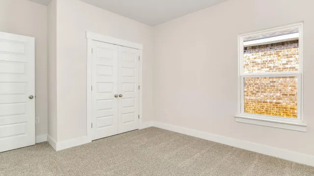an empty room with windows and closet