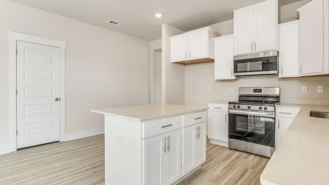 a kitchen with cabinets wooden floor and a sink