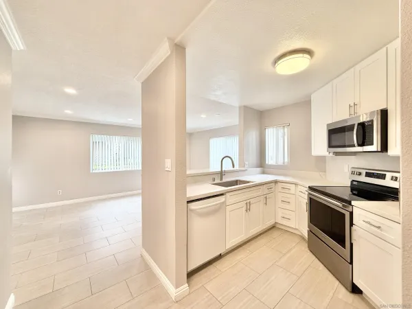 a kitchen with granite countertop a sink and white stainless steel appliances