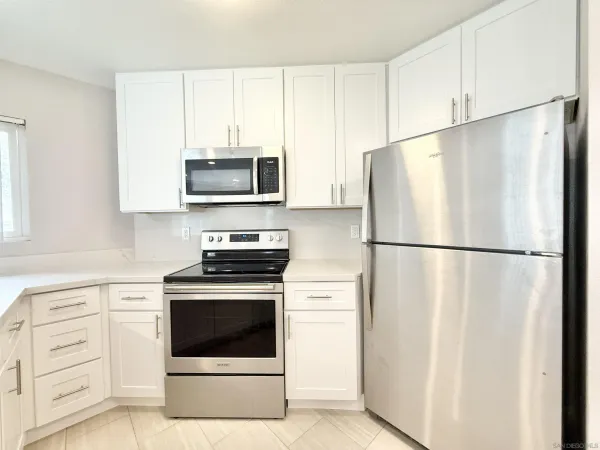 a white refrigerator freezer and a stove sitting inside of a kitchen