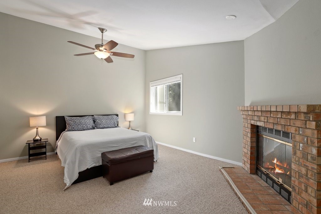 2102 186th Place Southeast Bothell, WA 98012 - Photo 17 of 31 a spacious bedroom with a bed and a fireplace