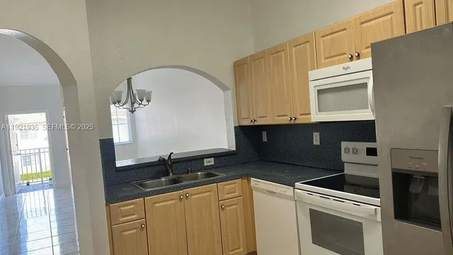 a kitchen with granite countertop a sink a stove and cabinets