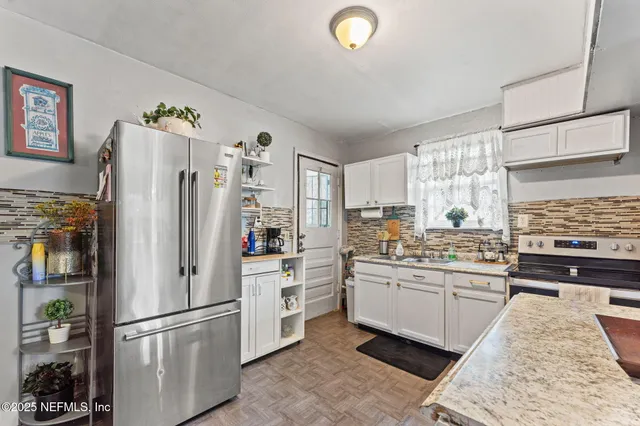 a kitchen with stainless steel appliances a refrigerator sink and stove