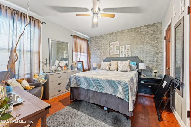 a bedroom with a bed and wooden floor