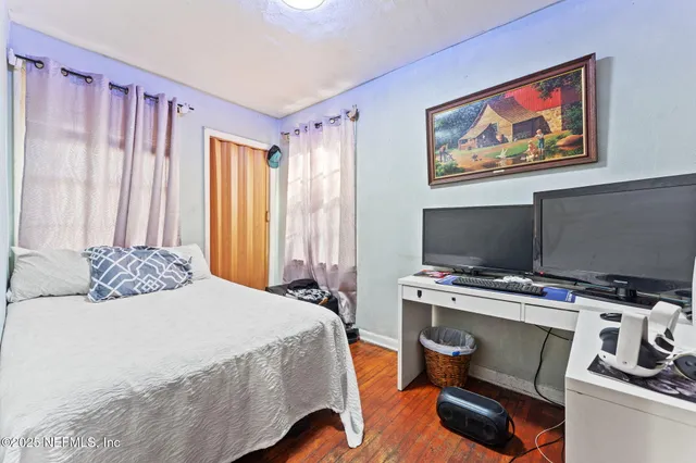 a bedroom with a bed and a flat screen tv